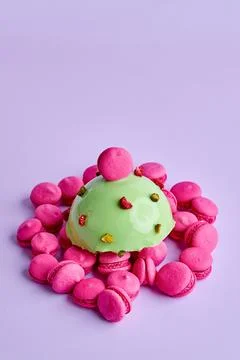 Mousse dessert on a pink background in a composition with small macaroons Stock Photos