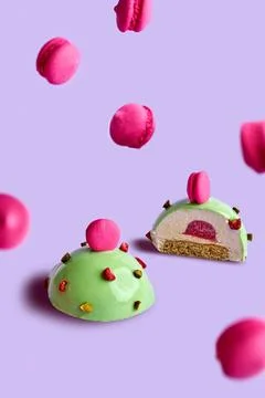 Mousse dessert on a pink background in a composition with small macaroons Stock Photos