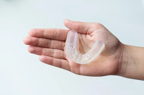 Mouth guard for bite alignment or teeth whitening on human palm Foto stock