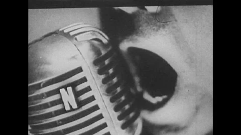 A mouth at a microphone, stacking documents, reports, men watching a film and Stock Footage 119704475