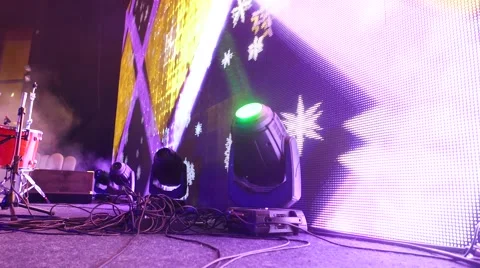 Movable lighting head against animated LED screen on concert hall stage Stock Footage 63224474