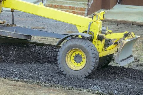 Movable motor grader with a blade performs the layout of a road crushed stone Stock Photos