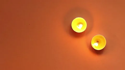 Movable pattern of lights from tea candles on an orange background, top view Stock Footage 195523094