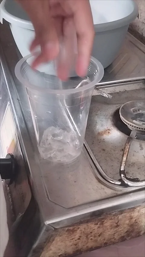 Move the crystal ice cubes into a plastic cup Stock Footage 294875849