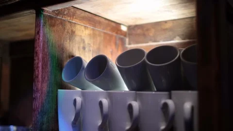 Move down from coffee mugs in lit cabinet Video stock 97094281