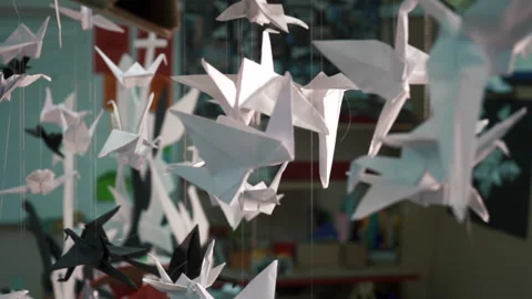 Move through Beautiful paper birds dangle in the wind under the roof. Stock Footage 197742003