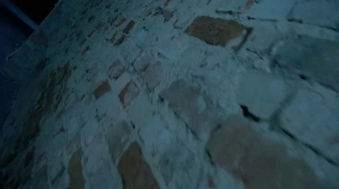 Movement along the old brick wall in a dark room. Stock Footage 11615613