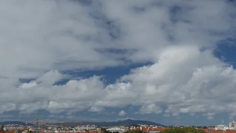 Movement of beautiful clouds in the blue sky over city houses. Stock Footage 251877841