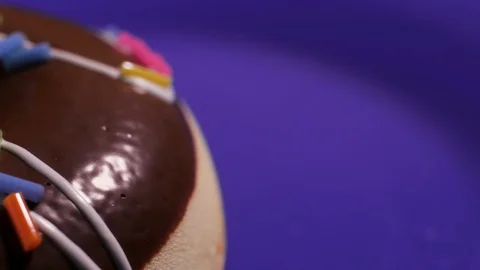 The movement of the camera around the donut in macro on a purple background Video stock 128657556
