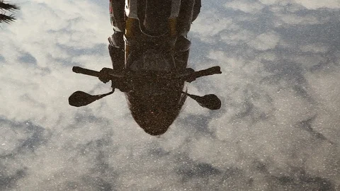 The movement of the camera from the reflection in the water up casual motorcycle Stock Footage 114558509