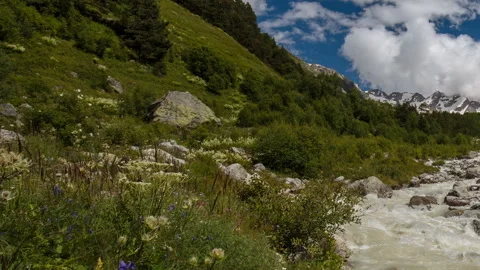 Movement of clouds and water flows in a stormy river in the Caucasus mountais Video stock 86990255