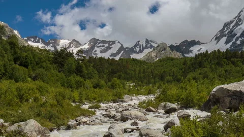 Movement of clouds and water flows in a stormy river in the Caucasus mountais Video stock 86990626