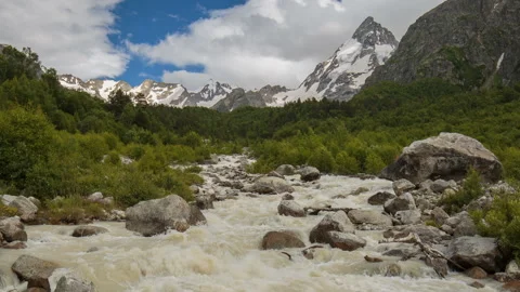 Movement of clouds and water flows in a stormy river in the Caucasus mountais Video stock 86994853
