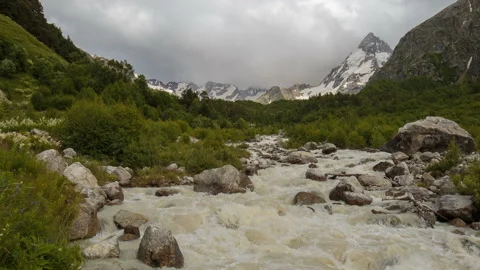 Movement of clouds and water flows in a stormy river in the Caucasus mountais Stock Footage 86994987