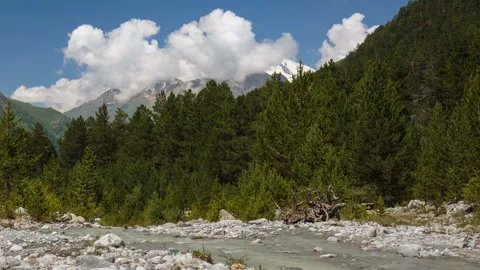 Movement of clouds and water flows in a stormy river in the Caucasus mountais Video stock 87347314