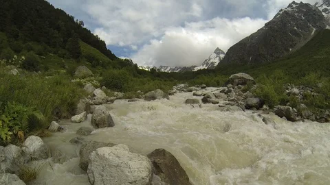Movement of clouds and water flows in a stormy river in the Caucasus mountains Video stock 87536596