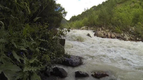 Movement of clouds and water flows in a stormy river in the Caucasus mountains Stock Footage 87537013