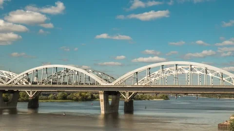 The movement of clouds over the bridge along which cars and trains, time lapse Stock Footage