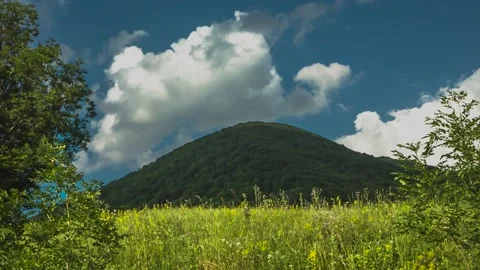 The movement of clouds over a green mountain slope Stock Footage 151425344