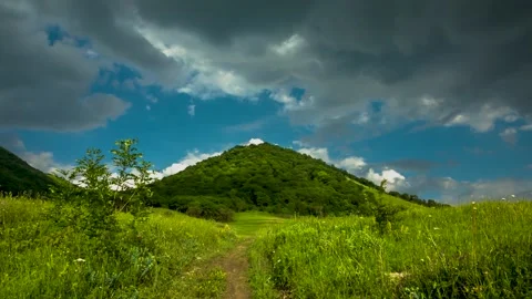 The movement of clouds over a green mountain slope Stock Footage 151425435