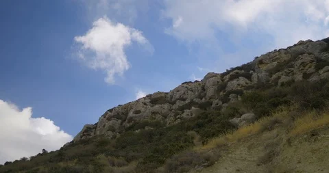 Movement of clouds over rocks Stock Footage 98128816