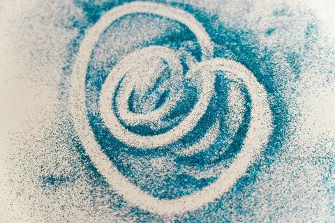 Movement of colored sand in a circular pattern on a flat surface Stock Photos