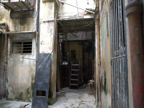 Movement into a courtyard of old dilapidated poor houses in the slums at 스톡 동영상 71037196