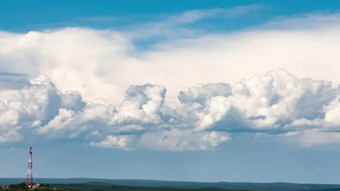 Movement of cumulus clouds behind a hill with a TV tower on top Stock Footage 202645338