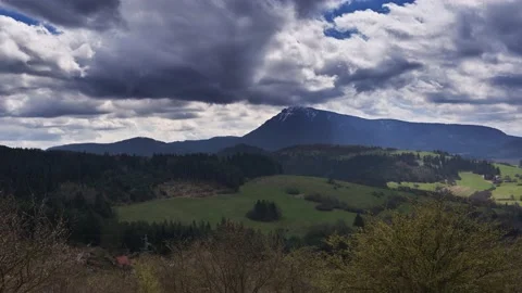 Movement of dense clouds over the spring landscape with a pointed mountain . Stock-Footage 168920505