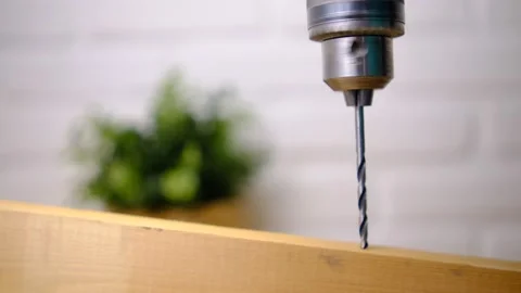The movement of a drill bit drilling wood. On a white blurred background with gr Stock Footage 147092910