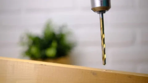 The movement of a drill bit drilling wood. On a white blurred background with gr Stock Footage 147093015