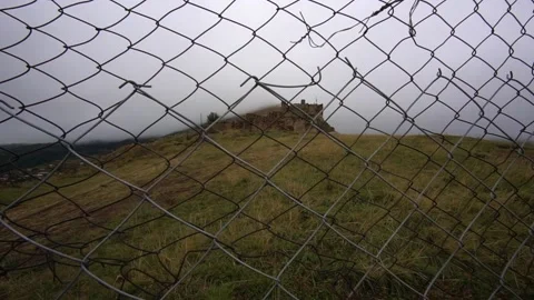 Movement forward to the chain-link fence with a view of the old town of Goor in Video stock 162634607