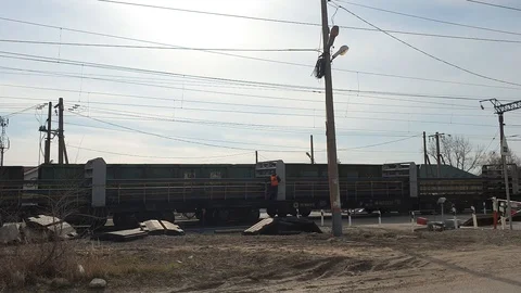 Movement of a freight train, a road crossing with a barrier over a railway Stock Footage 127827969