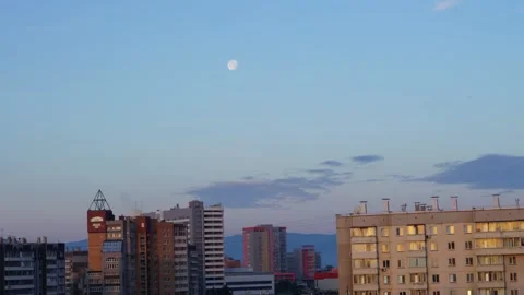 The movement of the full moon over the houses in the morning in the city Stock Footage 201323754