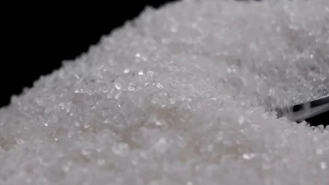The movement of grains of white sugar with a spoon on a black background. Stock Footage 170024063