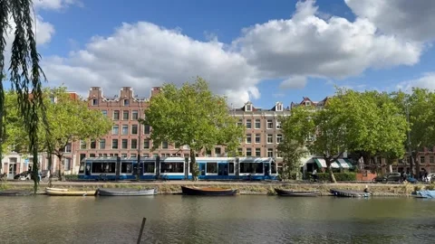 Movement of GVB tram, bicycles and cars traffic next to canal. Amsterdam Vídeo Stock 341938254