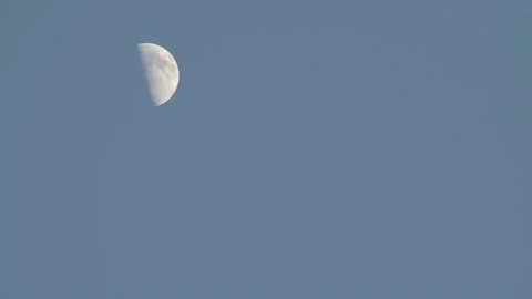 Movement of the half moon in the evening across the blue sky Stock Footage 156238543