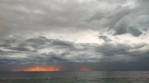 Movement large gray rain clouds, falling rain, yellow-orange spot of rising sun Stock Footage 212939181