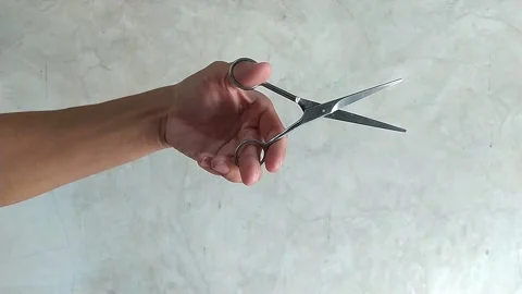 Movement of a man's hand holding a pair of scissors Vídeos de archivo 256349441
