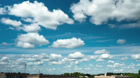 The movement of many small clouds over the rooftops. Video footage of a Stock Footage 156883436