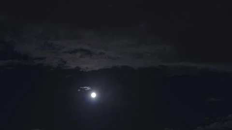 The movement of the moon in the sky through the clouds. Timelapse Stock Footage 65387041