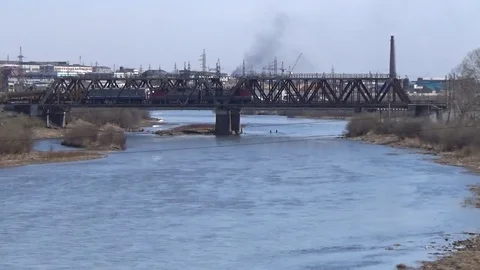 Movement of a railway train over a bridge over a river Stock Footage 75334832