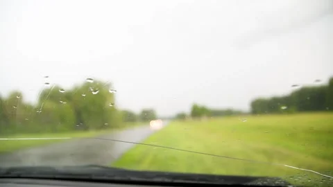 Movement of Rain falling on car windshield,drive car on street in city at heavy Stock-Footage 133860730