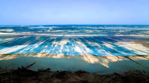 Movement of shadows from the forest on a frozen sandy beach and the sea Stock Footage 78627751