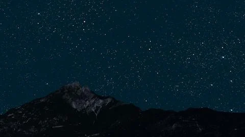 A movement of stars in the night sky with the view of mountains. 写真素材