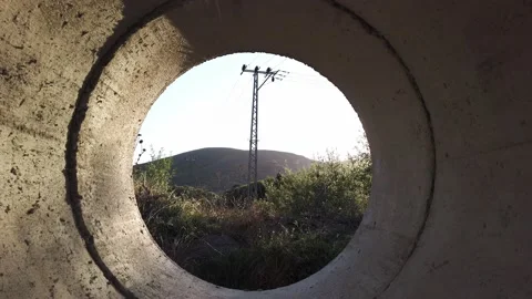 Movement through a gray concrete pipe. Power transmission tower. Stock Footage 137959327