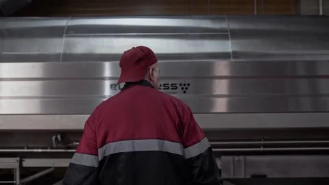 Movement of a uniformed winery worker to a large pneumatic press to squeeze Stock Footage 268750858