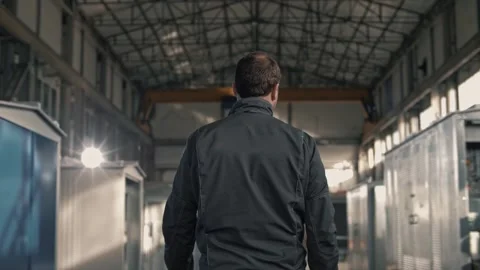 Movement of a uniformed worker from the back through the shop floor Stock Footage 265509277