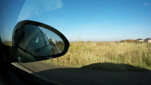 The movement of the vehicles behind is shown in the right side mirror of the car Stock Footage 106672680