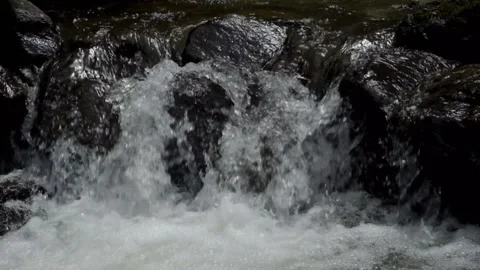 The movement of water falling through a rocky river cascade Stock Footage 297650847